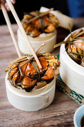 Chinese traditional cuisine in a steamer steamed Yangcheng Lake hairy crabs and seasoned vinegar ginger shreds in a dish. 779640030049599596