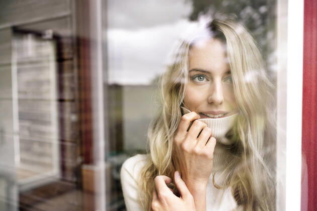 Close-up of businesswoman wearing turtleneck looking through window from office seen through glass model released Symbolfoto property released PESF02070