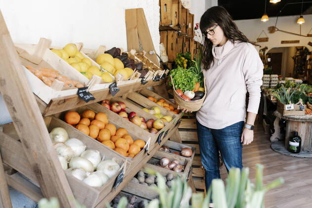 Female customer picking vegetables in basket from grocery store model released Symbolfoto property released RDGF00060