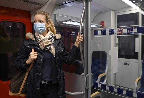 Frau mit Mundschutzmaske, steht in S-Bahn, Corona-Krise, Stuttgart, Baden-Württemberg, Deutschland Coronavirus