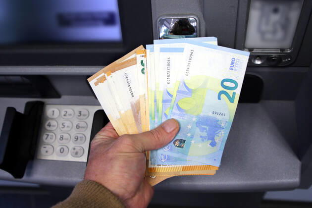 Bargeldversorgung aus einem Automat Eine Person holt an einem Geldautomaten eine größere Menge Bargeld in 50 und 20 Euro Geldscheinen ab