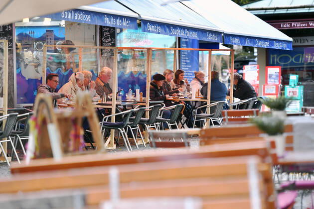 Themenbild: Coronavirus Pandemie Folgen fuer die Gastronomie. Gaeste sitzen im Aussenbereich eines Fisch Restaurants in der Innenstadt von Muenchen am 27.10.2020. Zwischen den Tischen stehen Plexiglaswaende zum Schutz der Gaeste vor dem Coroanvirus, Ab dem 2.November muss wegen dem Lockdown light die Gastronomie geschlossen bleiben, Schliessung-Folge der Corona Pandemie,Lockdown,Shutdown,Inzidenzwert.