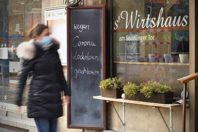 Themenbild: Coronavirus Pandemie Folgen fuer die Gastronomie. Schild am Wirtshaus am Sendlinger Tor; WEGEN CORONA LOCKDOWN GESCHLOSSEN, eine junge Frau,Passantin geht vorbei. Geschlossenes bayerisches Restaurant am Sendlinger Tor in Muenchen. Seit dem 2.November muss wegen dem Lockdown light die Gastronomie geschlossen bleiben, Schliessung-Folge der Corona Pandemie,Lockdown,Shutdown,Inzidenzwert. MODEL RELEASED!