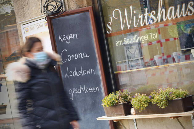 Themenbild: Coronavirus Pandemie Folgen fuer die Gastronomie. Schild am Wirtshaus am Sendlinger Tor; WEGEN CORONA LOCKDOWN GESCHLOSSEN, eine junge Frau,Passantin geht vorbei. Geschlossenes bayerisches Restaurant am Sendlinger Tor in Muenchen. Seit dem 2.November muss wegen dem Lockdown light die Gastronomie geschlossen bleiben, Schliessung-Folge der Corona Pandemie,Lockdown,Shutdown,Inzidenzwert. MODEL RELEASED!
