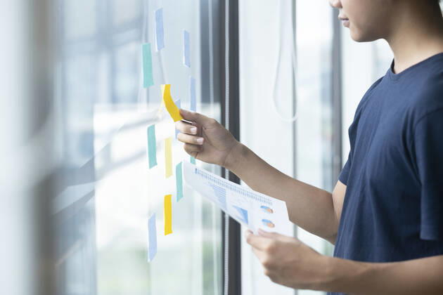 Creative man reading sticky notes on glass wall Chiang Mai, ?.?????????, Thailand CR_SIME201026A-537648-01 ,model released, Symbolfoto