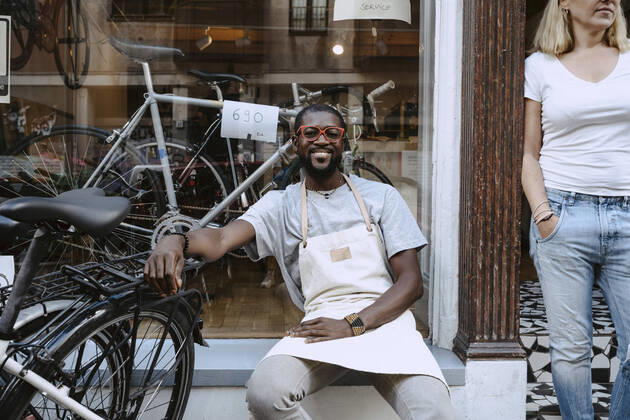 IMAGO Creative: Kreative Renaissance -- der junge Entrepreneur Portrait of confident owner sitting against bicycle shop, MA82932, Germany, Berlin, model released, property released Copyright: xMaskotx