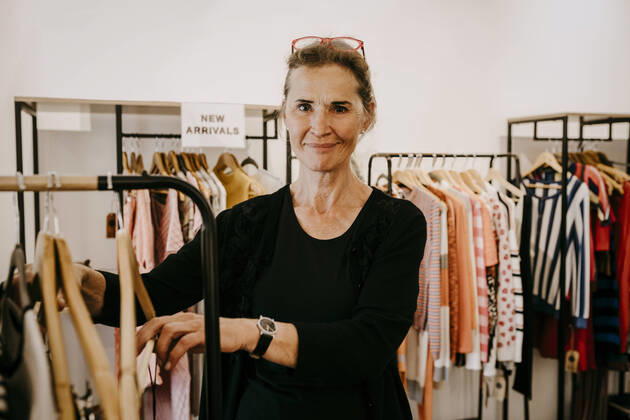 Portrait of smiling senior owner arranging clothes in store, MA82952, Germany, Berlin, model released, property released Copyright: xMaskotx