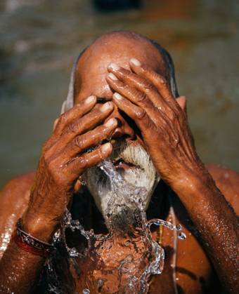 IMAGO Creative: 2021 Favoriten Allahabad, India - February, 2018:gray-haired man splashing and performing ritual bath in water in Prayag Kumbh Mela Festival Copyright: xEkaitzxGeriquex Model Released