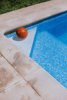 From above of basketball ball in corner on swimming pool in terrace of house with green grass Copyright: xEkaitzxGeriquex Model Released