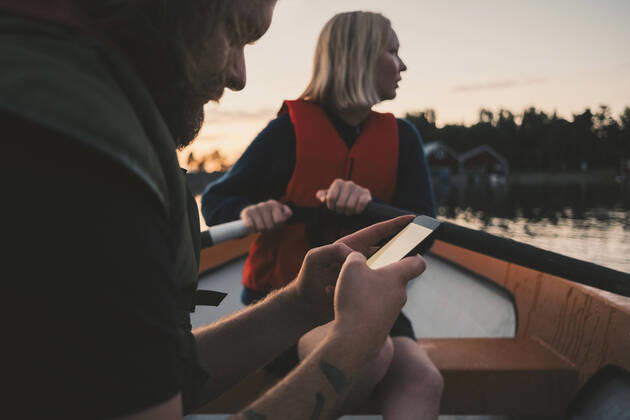 IMAGO Creative: Klimawandel - Zukunft und Innovation Man using mobile phone while woman rowing boat on lake , model released Copyright: xMaskotx , MA58781
