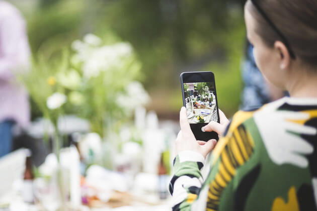 IMAGO Creative: Landleben - Essen Cropped image of woman photographing dining table through mobile phone in backyard , model released, property released Copyright: xMaskotx , MA66923