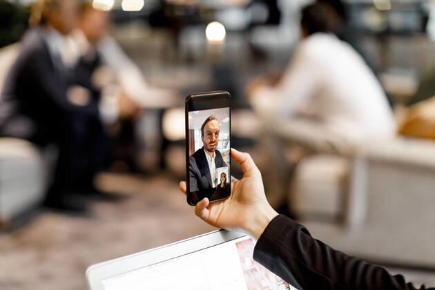 Male and female colleagues talking through video conference on smart phone in office Sweden, Stockholm, model released, property released Copyright: xMaskotx , MA79488