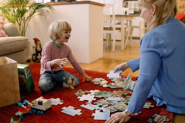 IMAGO Creative: Jahreszeit Winter, Fantasievoll drinnen spielen Cheerful boy playing jigsaw puzzle with grandmother in living room Sweden, Stockholm, model released, property released Copyright: xMaskotx , MA80215