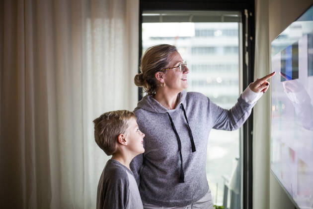 Mother guiding son in using smart TV at home Sweden, Stockholm, model released, property released Copyright: xMaskotx , MA80370