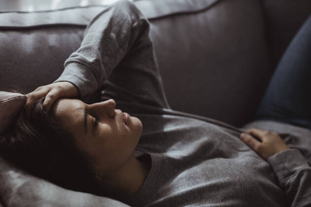 Close-up of stressed woman lying on sofa at home Sweden, Stockholm, model released, property released Copyright: xMaskotx , MA80486