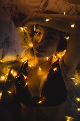 From above young beautiful woman in underwear lying in bed surrounded by light garland, Model released Copyright: xMURxStudiosx MR