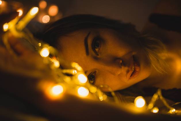 From above young beautiful woman in underwear lying in bed surrounded by light garland, Model released Copyright: xMURxStudiosx MR