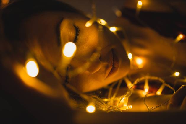 From above young beautiful woman in underwear lying in bed surrounded by light garland, Model released Copyright: xMURxStudiosx MR