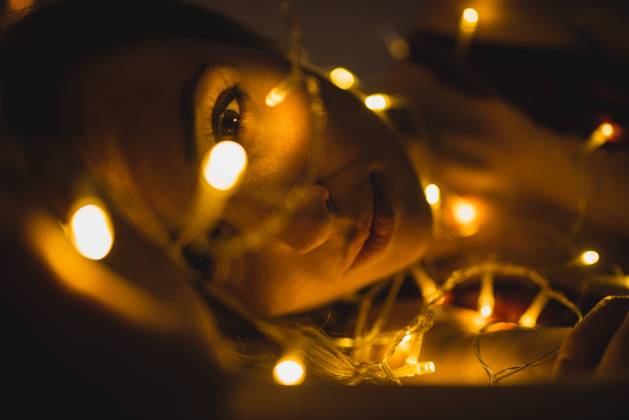From above young beautiful woman in underwear lying in bed surrounded by light garland, Model released Copyright: xMURxStudiosx MR