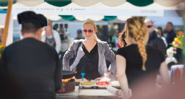 Woman buying meal at street food festival. Beautiful blonde caucasian lady buying freshly prepared meal at a local street food festival. Urban international kitchen event in Ljubljana, Slovenia, in summertime., model releasedwoman, food, market, grill, barbecue, street, people, young, shop, beautiful, healthy, outdoors, festival, fresh, lady, customer, urban, female, city, face, drink, stall, european, buy, vegetable, person, lifestyle, produce, attractive, summer, beverage, purchase, organic, portrait, marketplace, tourism, tourist, event, market stall, market stand, leisure, buying, stand, juise, sunglasses, cook, hat, casual, crowd, look,
