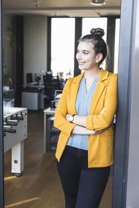 Female entrepreneur standing with arms crossed on entrance of office model released Symbolfoto property released UUF22107