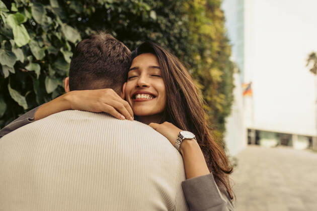 Smiling girlfriend embracing boyfriend at park model released Symbolfoto VABF04207