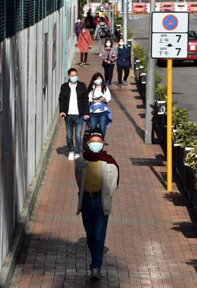 (210103) -- HONG KONG, Jan. 3, 2021 -- People wearing face masks walk on a street in Hong Kong, south China, Jan. 3, 2021. Hong Kong s Center for Health Protection reported 41 additional confirmed cases of COVID-19 on Sunday, taking its tally to 8,964. The new cases included 40 local infections, with 16 cases of unknown origin. ) CHINA-HONG KONG-COVID-19-CASES (CN) LoxPingxFai