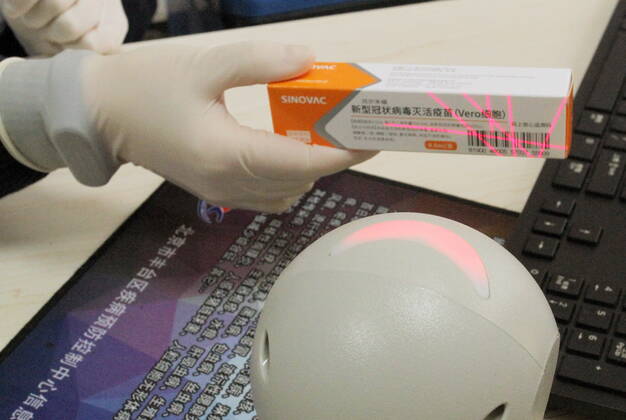 (210103) -- BEIJING, Jan. 3, 2021 -- A medical worker scans a dose of COVID-19 vaccine and prepares for inoculation in Beijing, capital of China, Jan. 3, 2021. Authorities in Wanping Town of Fengtai District in Beijing organized COVID-19 vaccine inoculation on Sunday for nearly 200 workers from key sectors and institutions including community service, fire-fighting, elderly care, and medical service. A total of 73,537 people in 220 inoculation venues across Beijing have received the first dose of COVID-19 vaccine in two days since the city began administering the jab among specific groups of people with higher infection risks on Friday. No serious side effects have been observed among the vaccine receivers, Gao Xiaojun, a spokesperson
