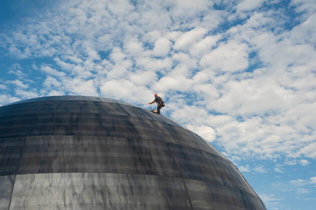 05.01.2021, Singapur, Republik Singapur, Asien - Ein Arbeiter verrichtet Wartungsarbeiten an der kuppelfoermigen Glasfassade des neuen Apple-Vorzeigegeschaefts (Flagshipstore) in Marina Bay Sands. Die futuristische Architektur des modernen Einzelhandelsgeschaefts hat die Form einer riesigen Glaskugel, die auf dem Wasser schwebt und ist der dritte Apple Store im suedostasiatischen Stadtstaat. Entworfen wurde das Gebaeude vom englischen Star-Architekten Sir Norman Foster (Foster and Partners). Die schwer vom Handel abhaengige Wirtschaft der Finanzmetropole erlitt im letzten Jahr auf Grund der Corona-Pandemie die schlimmste Rezession in ihrer jungen Geschichte und verzeichnete einen Rueckgang des BIP um 5,8 Prozent.