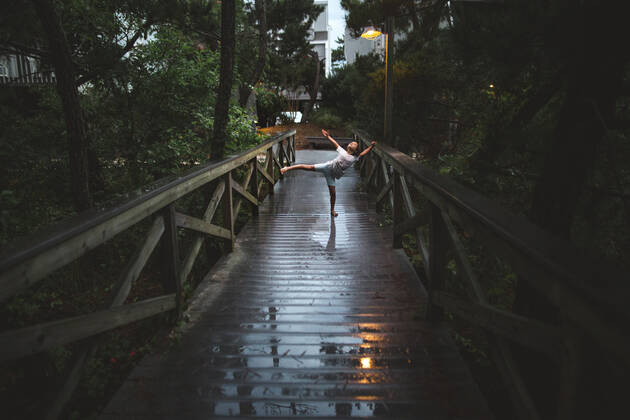 IMAGO Creative: Ende des Sommers A graceful child dances in lamplight on rainy boardwalk at night Bethany Beach, DE, United States CR_RETI210106-479818-01 ,model released, Symbolfoto