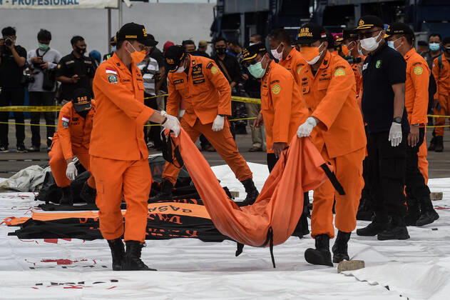 Bilder des Jahres 2021, News 01 Januar News Themen der Woche KW01 News Bilder des Tages (210110) -- JAKARTA, Jan. 10, 2021 -- Members of the Indonesian Search and Rescue (SAR) team carry body parts of passengers on board the Sriwijaya Air flight SJ-182 at Tanjung Priok Port, Jakarta, Indonesia, Jan. 10, 2021. Rescuers on Sunday collected five bags of human body parts and three bags of debris of the Sriwijaya Air plane that crashed in the waters off the coast of Indonesian capital Jakarta, a senior official said. (Photo by Xinhua) INDONESIA-JAKARTA-PLANE CRASH-SEARCH AgungxKuncahyaxB.