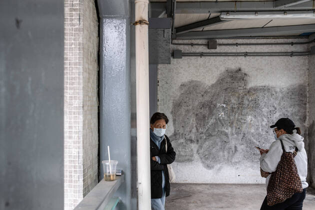 January 10, 2021, Hong Kong, Hong Kong: People wearing face masks as a precaution against the spread of Covid-19 walk past a wall with covered protest graffiti in Lok Fu. Hong Kong Hong Kong - ZUMAs197 20210110_zaa_s197_054 Copyright: xIsaacxWongx