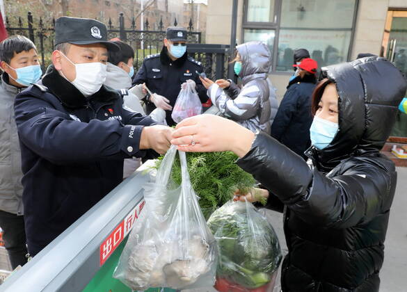 (210110) -- SHIJIAZHUANG, Jan. 10, 2021 -- Police officers help distribute vegetables for residents in Shijiazhuang, north China s Hebei Province, Jan. 10, 2021. In order to stop the spread of the epidemic, the police in Shijiazhuang stick to their posts on Sunday, the day marking the first Chinese People s Police Day. ) CHINA-HEBEI-SHIJIAZHUANG-POLICE DAY-COVID-19 (CN) YangxShiyao 