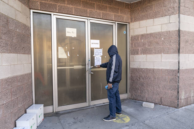 First day of mass vaccination in NYC Jose who lives nearby checks signs on the building where eligible and registered people will get COVID-19 vaccine at Bathgate Contract Postal Station. People over 75, education workers, the police and firefighters, public transit and safety workers are eligible to get vaccine as group 1B. Group 1A includes healthcare workers. More than 600 people registered to get vaccinated on this location on the first day. New York New York United States Copyright: LevxRadin