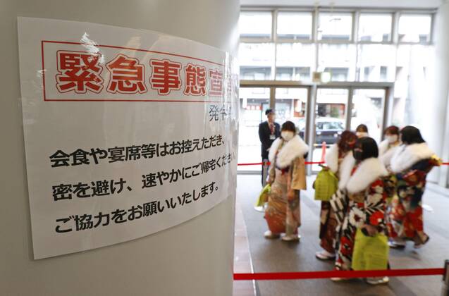 Coming-of-age ceremony under virus state of emergency Photo taken at the venue of a coming-of-age ceremony in Tokyo s Suginami Ward on Jan. 11, 2021, shows a sign asking attendees to refrain from eating or drinking together after the ceremony as the capital is under a coronavirus state of emergency. 