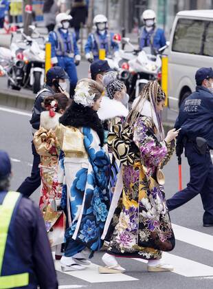 Coming-of-age ceremony under virus state of emergency Women in kimono walk near the venues of a coming-of-age ceremony in Yokohama near Tokyo on Jan. 11, 2021. The ceremony was split into two venues to avoid concentration of people as the Tokyo metropolitan area is under a coronavirus state of emergency amid the continued pandemic.