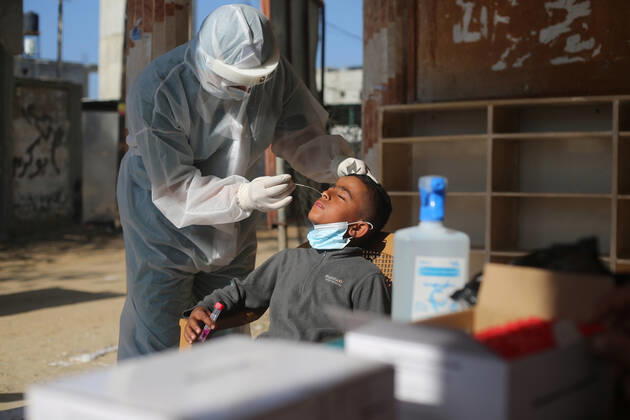(210111) -- RAFAH, Jan. 11, 2021 -- A medical worker collects a swab sample from a boy to test for the COVID-19 in the southern Gaza Strip city of Rafah, Jan. 11, 2021. (Photo by Xinhua) MIDEAST-GAZA-RAFAH-COVID-19-TEST KhaledxOmar 