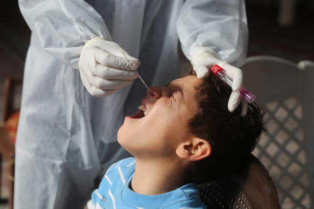 (210111) -- RAFAH, Jan. 11, 2021 -- A medical worker collects a swab sample from a boy to test for the COVID-19 in the southern Gaza Strip city of Rafah, Jan. 11, 2021. (Photo by Xinhua) MIDEAST-GAZA-RAFAH-COVID-19-TEST KhaledxOmar 