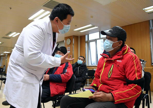(210111) -- BEIJING, Jan. 11, 2021 -- A medical worker (1st L) inquires a recipient of his physical condition after receiving a COVID-19 vaccine shot at a temporary inoculation site in Haidian District in Beijing, capital of China, Jan. 11, 2021. Over 1 million people in Beijing had received the first dose of COVID-19 vaccine as of 11 a.m. Monday, the municipal health commission said. TO GO WITH Over 1 mln get COVID-19 vaccine in Beijing ) CHINA-BEIJING-COVID-19 VACCINE-1 MILLION-INOCULATIONS (CN) RenxChao 