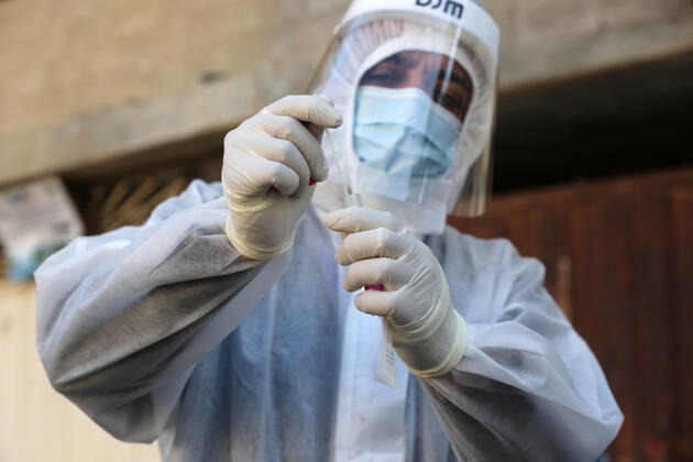 January 11, 2021, Deir Al-Balah, Gaza Strip, Palestinian Territory: A Palestinian medical worker wearing protective gear, takes a random swab sample for COVID-19 testing inside a mosque, in Deir al-Balah, central of Gaza Strip, on January 11, 2021. The Palestinian Authority (PA) has said it expects to receive its first COVID-19 vaccine doses in March under a deal with British drug giant AstraZeneca, and accused Israel of ignoring its responsibilities to ensure vaccines are available in occupied territory Deir Al-Balah Palestinian Territory - ZUMAap3_ 20210111_zaf_ap3_033 Copyright: xAshrafxAmrax