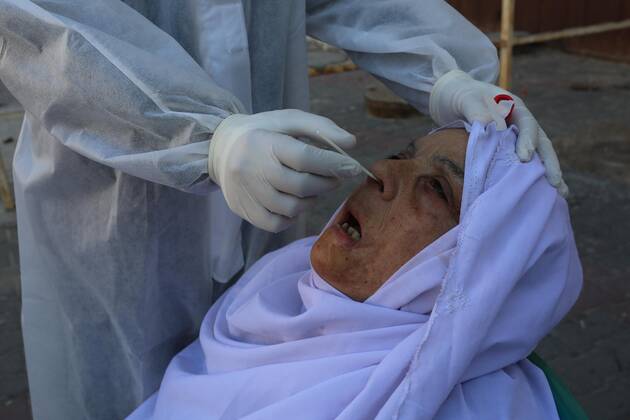 January 11, 2021, Deir Al-Balah, Gaza Strip, Palestinian Territory: A Palestinian medical worker wearing protective gear, takes a random swab sample for COVID-19 testing, in Deir al-Balah, central of Gaza Strip, on January 11, 2021. The Palestinian Authority (PA) has said it expects to receive its first COVID-19 vaccine doses in March under a deal with British drug giant AstraZeneca, and accused Israel of ignoring its responsibilities to ensure vaccines are available in occupied territory Deir Al-Balah Palestinian Territory - ZUMAap3_ 20210111_zaf_ap3_044 Copyright: xAshrafxAmrax