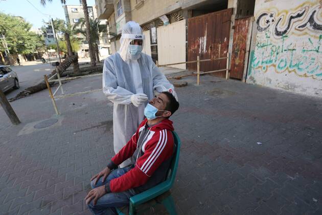 January 11, 2021, Deir Al-Balah, Gaza Strip, Palestinian Territory: A Palestinian medical worker wearing protective gear, takes a random swab sample for COVID-19 testing, in Deir al-Balah, central of Gaza Strip, on January 11, 2021. The Palestinian Authority (PA) has said it expects to receive its first COVID-19 vaccine doses in March under a deal with British drug giant AstraZeneca, and accused Israel of ignoring its responsibilities to ensure vaccines are available in occupied territory Deir Al-Balah Palestinian Territory - ZUMAap3_ 20210111_zaf_ap3_047 Copyright: xAshrafxAmrax