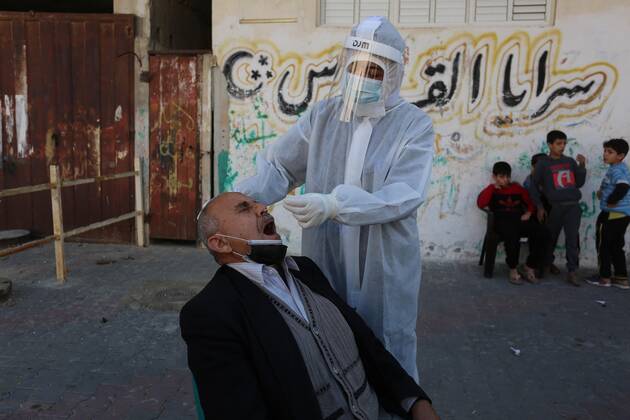 January 11, 2021, Deir Al-Balah, Gaza Strip, Palestinian Territory: A Palestinian medical worker wearing protective gear, takes a random swab sample for COVID-19 testing, in Deir al-Balah, central of Gaza Strip, on January 11, 2021. The Palestinian Authority (PA) has said it expects to receive its first COVID-19 vaccine doses in March under a deal with British drug giant AstraZeneca, and accused Israel of ignoring its responsibilities to ensure vaccines are available in occupied territory Deir Al-Balah Palestinian Territory - ZUMAap3_ 20210111_zaf_ap3_048 Copyright: xAshrafxAmrax