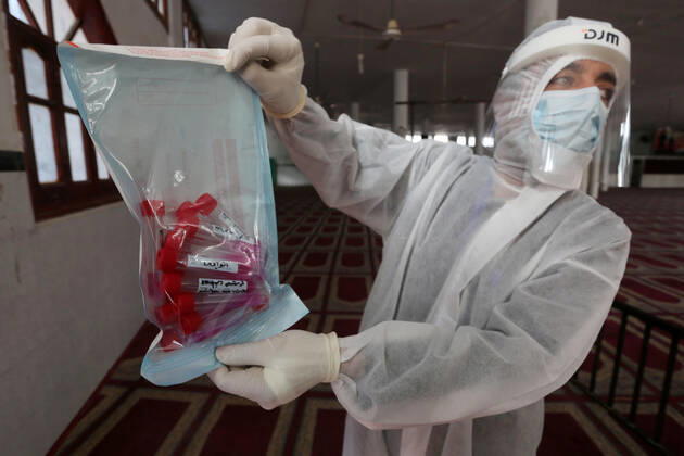 January 11, 2021, Deir Al-Balah, Gaza Strip, Palestinian Territory: A Palestinian medical worker wearing protective gear, takes a random swab sample for COVID-19 testing inside a mosque, in Deir al-Balah, central of Gaza Strip, on January 11, 2021. The Palestinian Authority (PA) has said it expects to receive its first COVID-19 vaccine doses in March under a deal with British drug giant AstraZeneca, and accused Israel of ignoring its responsibilities to ensure vaccines are available in occupied territory Deir Al-Balah Palestinian Territory - ZUMAap3_ 20210111_zaf_ap3_060 Copyright: xAshrafxAmrax