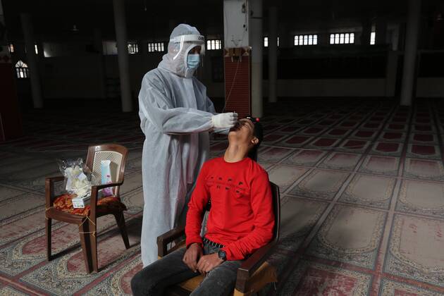 January 11, 2021, Deir Al-Balah, Gaza Strip, Palestinian Territory: A Palestinian medical worker wearing protective gear, takes a random swab sample for COVID-19 testing inside a mosque, in Deir al-Balah, central of Gaza Strip, on January 11, 2021. The Palestinian Authority (PA) has said it expects to receive its first COVID-19 vaccine doses in March under a deal with British drug giant AstraZeneca, and accused Israel of ignoring its responsibilities to ensure vaccines are available in occupied territory Deir Al-Balah Palestinian Territory - ZUMAap3_ 20210111_zaf_ap3_064 Copyright: xAshrafxAmrax