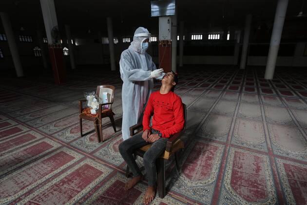 January 11, 2021, Deir Al-Balah, Gaza Strip, Palestinian Territory: A Palestinian medical worker wearing protective gear, takes a random swab sample for COVID-19 testing inside a mosque, in Deir al-Balah, central of Gaza Strip, on January 11, 2021. The Palestinian Authority (PA) has said it expects to receive its first COVID-19 vaccine doses in March under a deal with British drug giant AstraZeneca, and accused Israel of ignoring its responsibilities to ensure vaccines are available in occupied territory Deir Al-Balah Palestinian Territory - ZUMAap3_ 20210111_zaf_ap3_070 Copyright: xAshrafxAmrax
