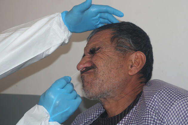 (210111) -- SHIBERGHAN, Jan. 11, 2021 -- A medical worker collects a swab sample from a man to test for the COVID-19 in Shiberghan, Jawzjan province, Afghanistan, Jan. 11, 2021. Afghanistan reported 46 new confirmed COVID-19 cases on Monday, raising its national tally to 53,584, including 8,588 active cases, the country s Ministry of Public Health said. (Photo by Xinhua) AFGHANISTAN-JAWZJAN-COVID-19-TEST MohammadxJanxAria