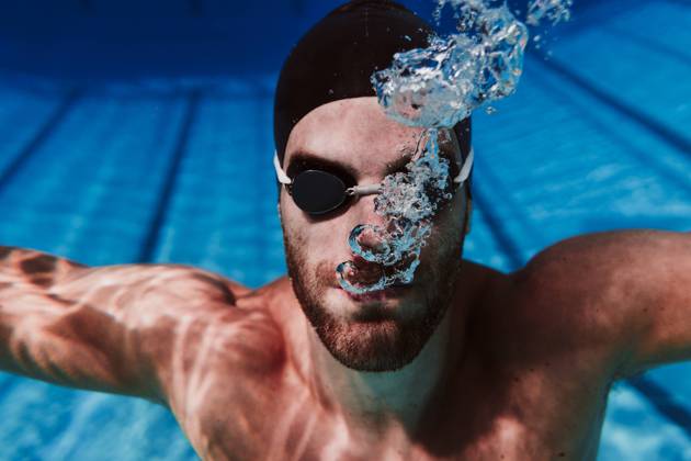 IMAGO Creative: Kulturelle Folgen der Pandemie: Gesundheitsbewußtsein und Alleinsein Young male swimmer diving in swimming pool model released Symbolfoto EBBF01314
