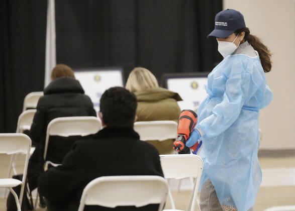 Workers sanitize areas where people sit and wait to receive a coronavirus vaccine at an Essex County COVID-19 Vaccination Site located at a closed Sears retail store in the Livingston Mall in Livingston, New Jersey on Monday, January 11, 2021. Public health agencies and health-care groups are using the retailer s empty stores to deliver Vaccines in several locations around parts of the United States.  NYP20210111116 JohnxAngelillo