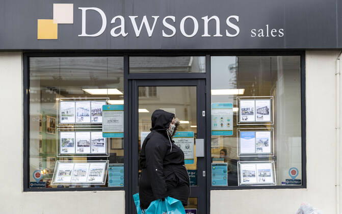 January 11, 2021, Newport, Wales, United Kingdom: A woman wearing a face mask walks past Dawsons property agent in Wales. Newport United Kingdom - ZUMAs197 20210111_zab_s197_015 Copyright: xMayxJamesx